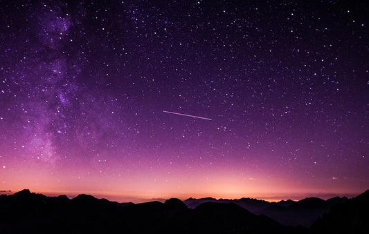 Milky Way galaxy stretching across a dark sky above mountains