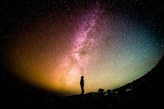 Night sky filled with stars and the Milky Way over ancient landscape